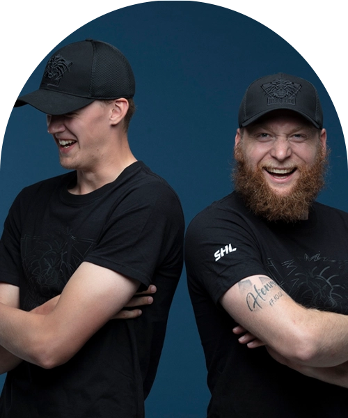 Två figurer i Linköpings svarta hockeyutrustning. Lejonloggor på kepsar (broderade) och tröjor (tryckta).